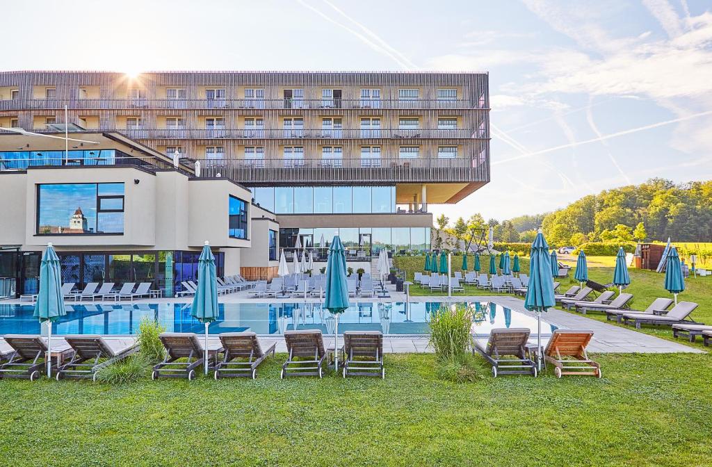 Pool mit Liegestühlen und Blick auf das Hotel Loisium